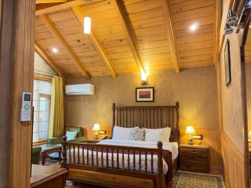 a bedroom with a bed and a wooden ceiling at Shivadya - A Luxury Boutique Experience in Manāli