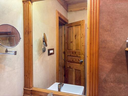 a bathroom with a sink and a wooden door at Shivadya - A Luxury Boutique Experience in Manāli