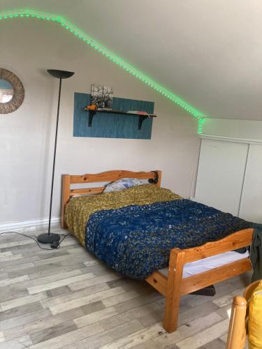 una camera da letto con un letto con una lampada e illuminazione verde di Maison pour 6 personnes avec jardin et piscine ad Artigues-près-Bordeaux