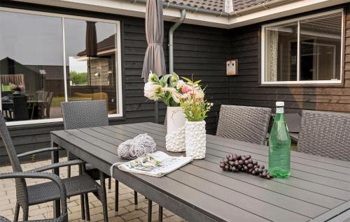a wooden table with a bottle of wine and flowers at Awesome Home In Sydals With Sauna in Sarup