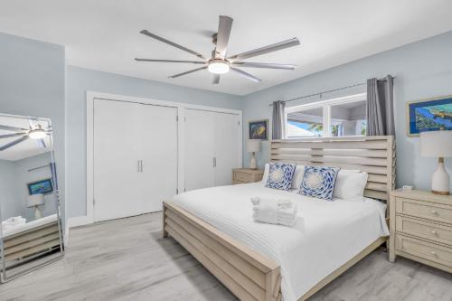 a bedroom with a bed and a ceiling fan at Sailfish Point - Luxury Waterfront Pool Home, 80' Dock in Key Colony Beach