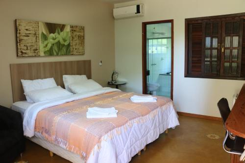 a bedroom with a bed with towels on it at Pousada Alto do Bau in Conceição do Mato Dentro