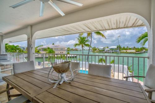 a wooden table on a balcony with a view of the water at Sailfish Point - Luxury Waterfront Pool Home, 80' Dock in Key Colony Beach