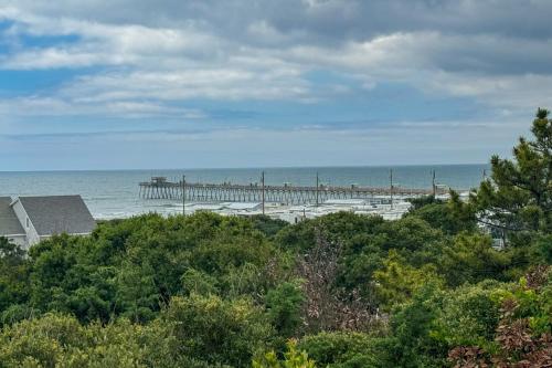a beach with a pier in the water at Coastal Love in Emerald Isle
