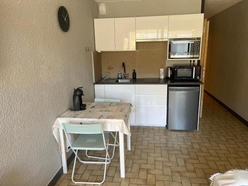 une cuisine avec une table et des chaises et un micro-ondes dans l'établissement Cavalaire, tout à proximité, à Cavalaire-sur-Mer