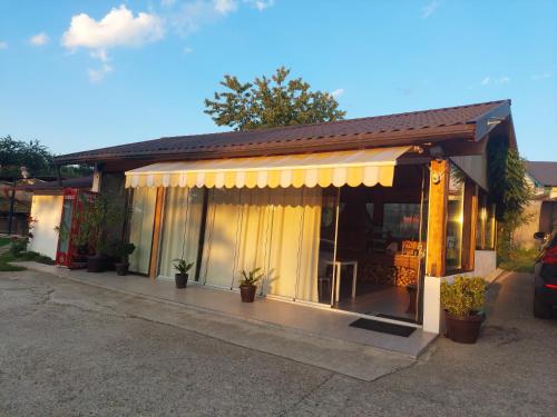 a small house with a yellow awning at Pensiunea Prestige House in Curtea de Argeş