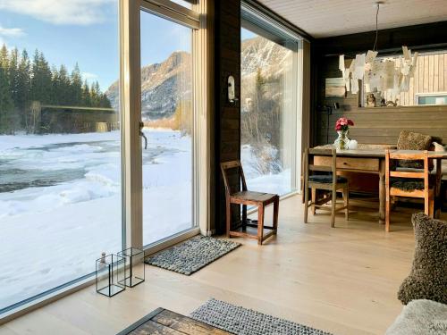 een eetkamer met een tafel en een groot raam bij Hytte Ved Heimsila I Hemsedal in Hemsedal