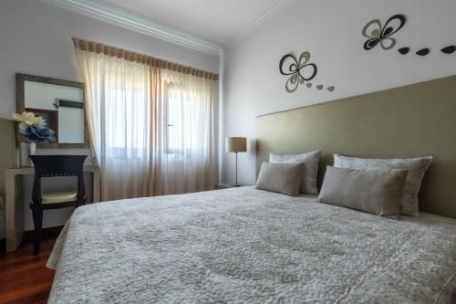a bedroom with a large bed and a desk at Residência Maciel in Peniche