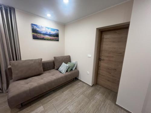 a living room with a couch and a wooden door at Dih narave in Stahovica
