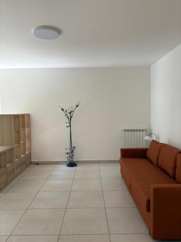 a living room with a couch and a vase with flowers at Case del Mare - Corallo, Perla, Acquamarina in Terracina
