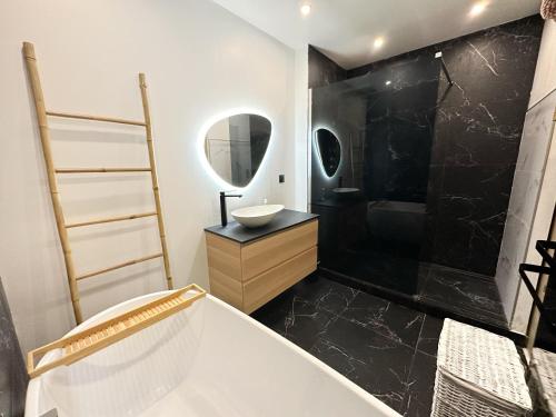 a bathroom with a tub and a sink and a mirror at Superbe appartement moderne in La Valette-du-Var
