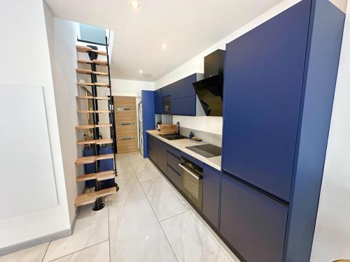 a kitchen with blue cabinets and a white floor at Superbe appartement moderne in La Valette-du-Var
