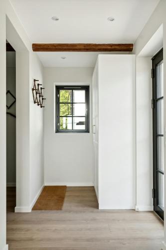 a hallway with white walls and a window at Enjoy Nature In A Thatched Annex From 1860 in Frørup