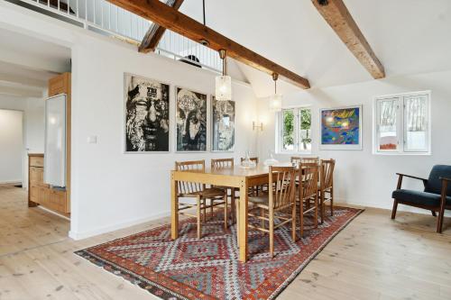 a dining room with a table and chairs on a rug at Renovated Estate With Private Beach in Roslev