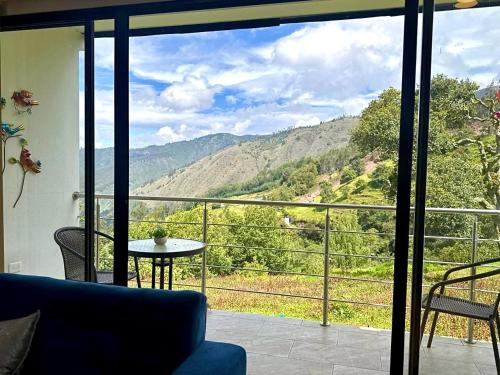 a living room with a view of a mountain at El Encanto - La Trinidad, cabaña con jacuzzi in Duitama