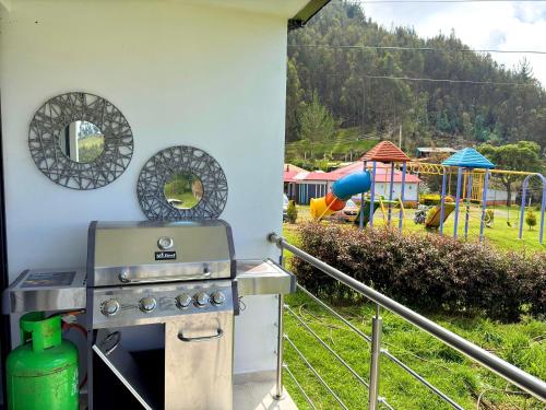 a outdoor grill with a playground in the background at El Encanto - La Trinidad, cabaña con jacuzzi in Duitama