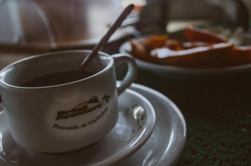 a cup of coffee on a plate with a bowl of food at Pousada Brésil Aventure in Galinhos