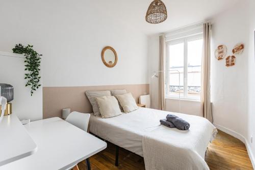 une chambre blanche avec deux lits et une fenêtre dans l'établissement Le cosy - charmant 2 chambres - centre, à Reims