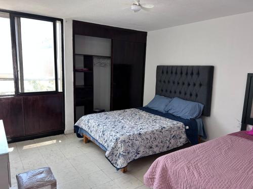 a bedroom with a bed and a large window at Casa Residencial Renacimiento in Celaya