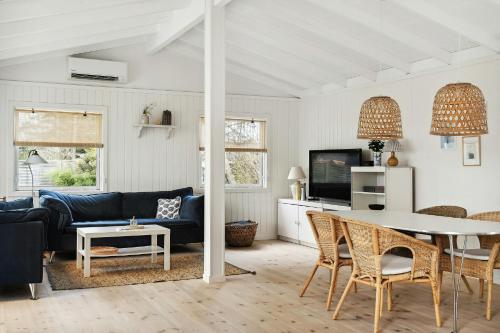 a living room with a blue couch and a table at Bright And Cozy Cottage Close To The Sea in Hornbæk