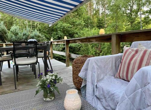 a patio with a couch and a table and chairs at House Near Woods And Fields In Mols Bjerge in Kolind