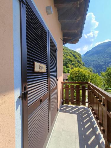 a door to a balcony with a view of the mountains at Agriturismo Cascina Lert in Marone
