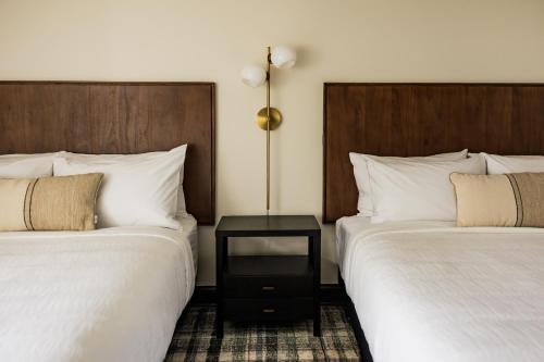 a hotel room with two beds and a side table at The Vic by Kasa in Traverse City