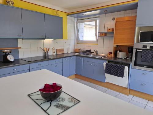 une cuisine avec des placards bleus et un comptoir blanc dans l'établissement Grande maison spacieuse pour 9 personnes, à Saint-Brieuc