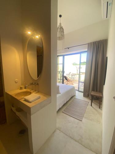 a bathroom with a sink and a mirror and a bed at Casa Amanhada Apartamento Zero in Grândola