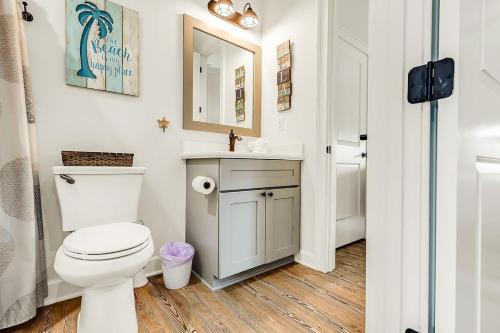 a bathroom with a toilet and a sink and a mirror at Sombrero Chic - Waterfront Pool Home Near Sombrero Beach, 40' Dock in Marathon