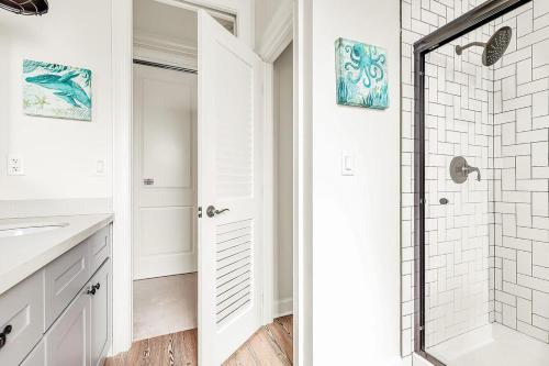 a bathroom with a shower and a sink and a mirror at Sombrero Chic - Waterfront Pool Home Near Sombrero Beach, 40' Dock in Marathon
