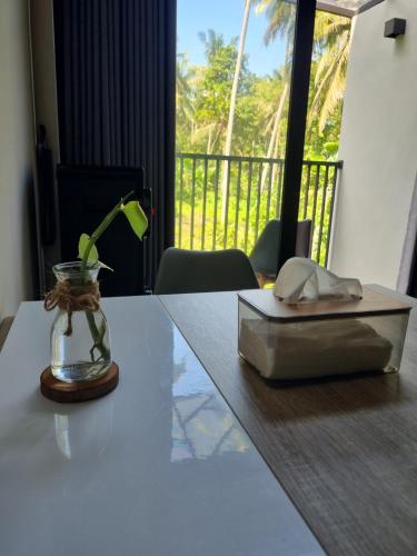 a table with a glass vase and a box on it at Happy Spiritus Guethouse Tabanan in Tabanan
