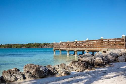 a pier on a beach with rocks in the water at Sombrero Chic - Waterfront Pool Home Near Sombrero Beach, 40' Dock in Marathon