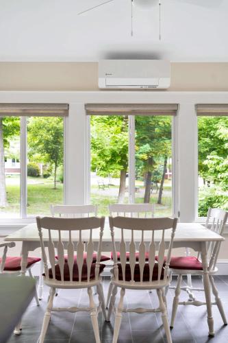 a dining room with a table and chairs and windows at The Firefly - 6 Chipmunk in Cherry Valley