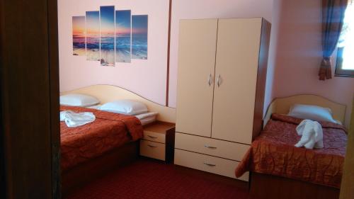 a small bedroom with two beds and a cabinet at Guest House Aristokrat in Obzor