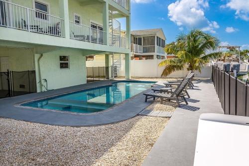 a swimming pool in front of a building at Tipsy Turtle - Waterfront Pool Home, Direct Atlantic Access! in Marathon