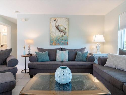 a living room with a couch and a table at Tiki Time - Waterfront Pool Home, 65` Dock , Direct Ocean Access! in Marathon