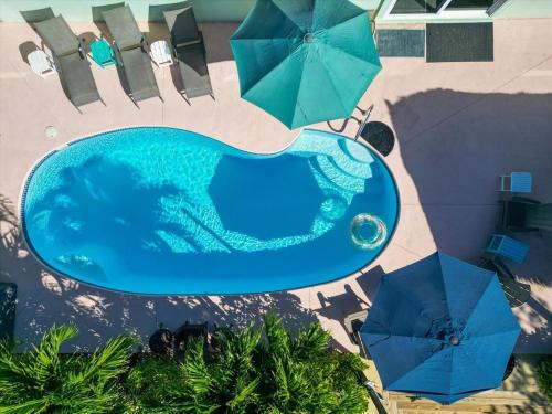 an overhead view of a swimming pool with two umbrellas at Tiki Time - Waterfront Pool Home, 65` Dock , Direct Ocean Access! in Marathon