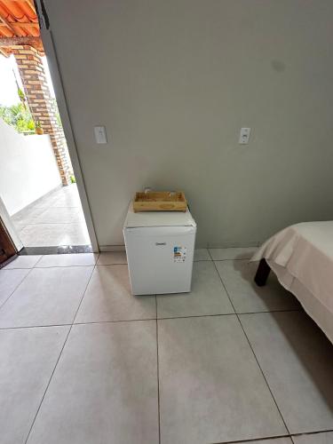 a room with a bed and a table with a box at Pousada Flor dos Buritis in Paulino Neves