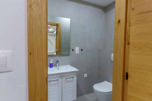 a bathroom with a sink and a toilet and a mirror at Motel Aqua Kozarac in Kozarac