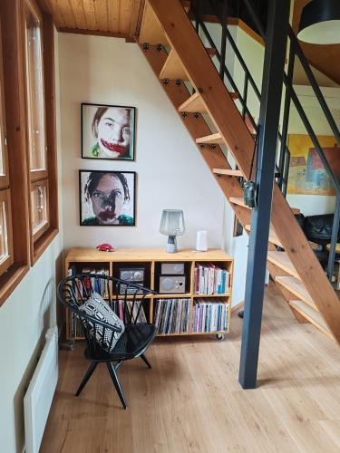a living room with a staircase and a chair at Villa Tammio in Uusikaupunki