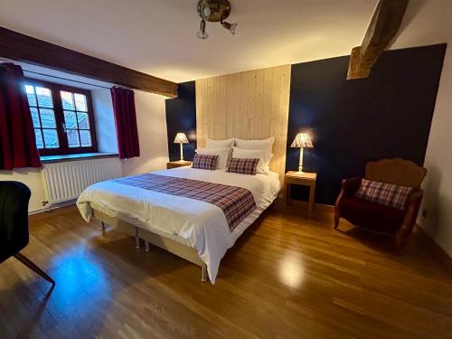 a bedroom with a large bed and a chair at Gîte " le Schmoutzi" Duplex centre historique Riquewihr in Riquewihr