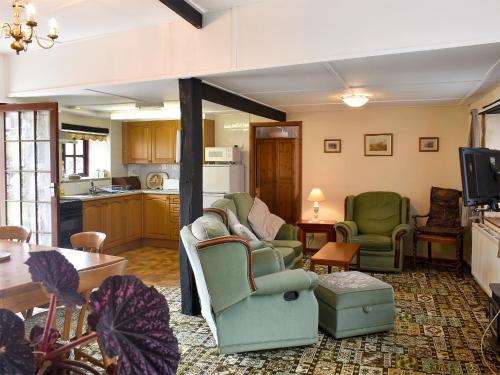 a living room with two chairs and a table at Lower Hameldown-Uk12424 in Widecombe in the Moor