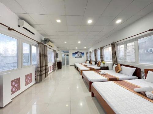 a row of beds in a room with windows at Hotel Kim Oanh in Vung Tau