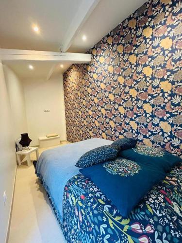 - une chambre dotée d'un lit bleu avec un mur aux accents floraux dans l'établissement Séjour idéal à Marseille - entre mer, soleil et confort, à Marseille