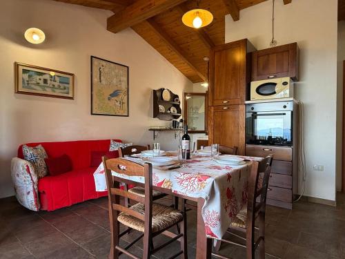 a living room with a table and a red couch at Dimora Cala-Vista in Torre Dei Corsari