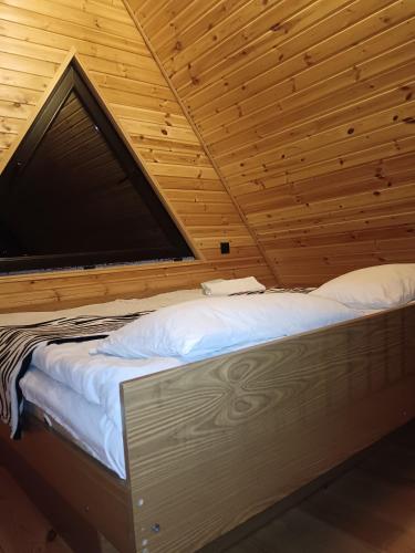 a bed in a room with a wooden ceiling at My house in Stepantsminda