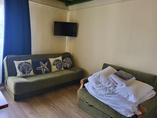 a living room with a couch and a tv at Błękit Bałtyku in Łazy