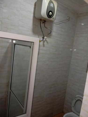a bathroom with a shower with a camera on the wall at Executive Studio Room in Enugu