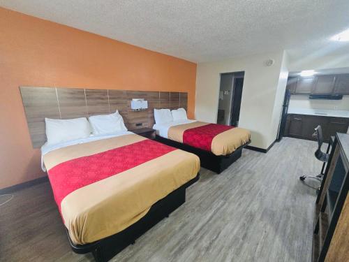 a hotel room with two beds and a kitchen at Studios 4 Less Chesapeake in Chesapeake